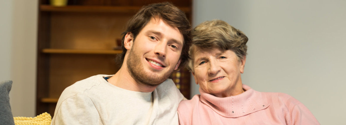 male caregiver and senior woman smiling